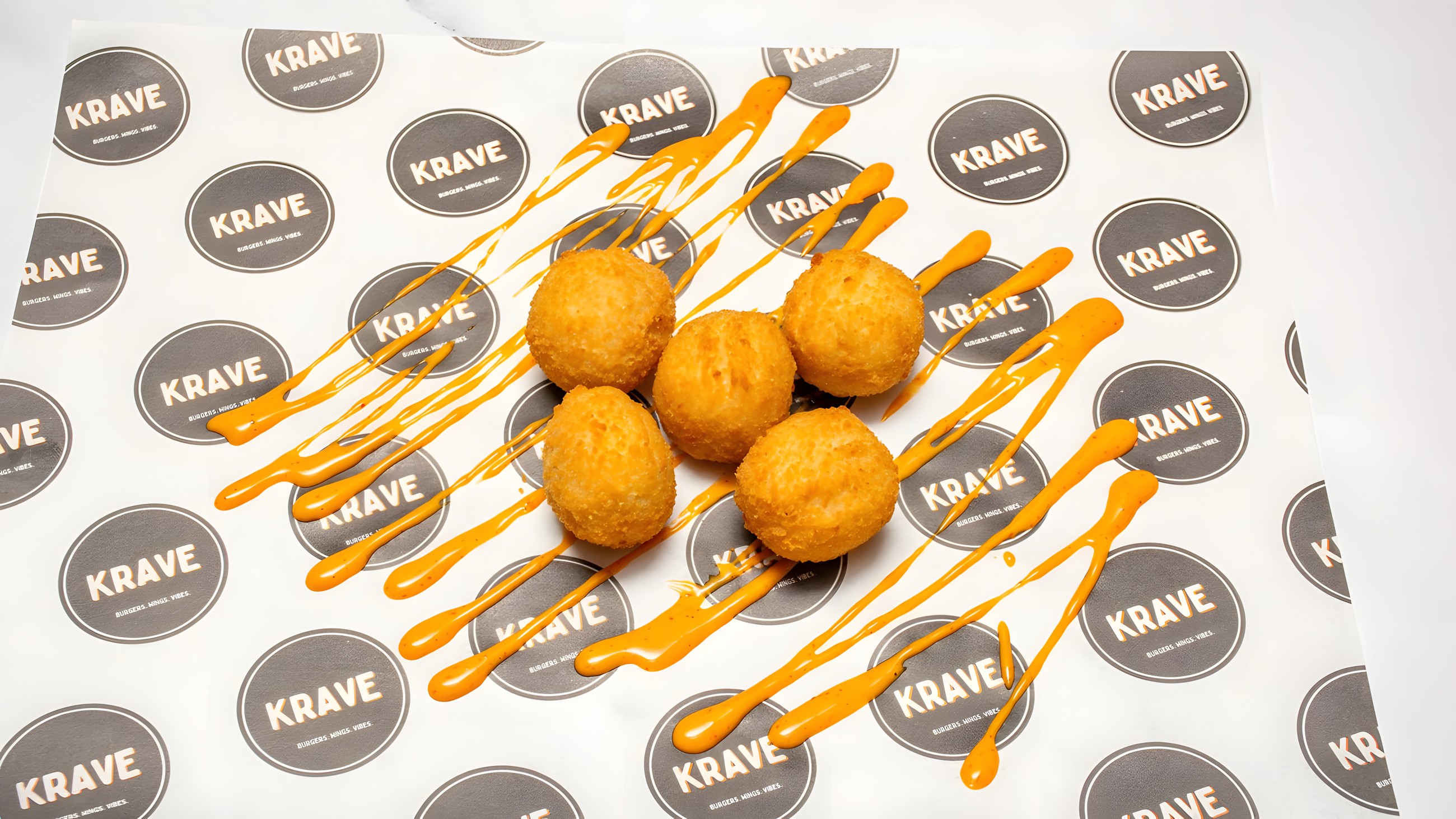 Golden cheese bites drizzled with burger sauce