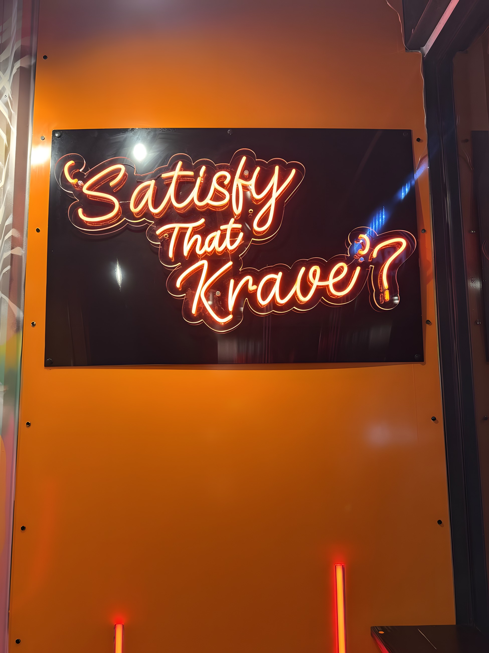 The Satisfy that Krave neon sign inside the Mile End shop